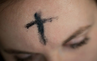 ash cross on the forehead of a woman